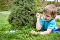 Kids on Easter egg hunt in blooming spring garden. Children searching for colorful eggs in flower meadow. Toddler boy and his brot