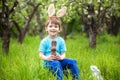 Kids on Easter egg hunt in blooming spring garden. Children searching for colorful eggs in flower meadow. Toddler boy and his brot Royalty Free Stock Photo