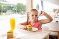 Kids eat cake at restaurant. Little girl in cafe Royalty Free Stock Photo