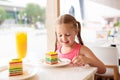 Kids eat cake at restaurant. Little girl in cafe Royalty Free Stock Photo