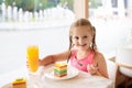 Kids eat cake at restaurant. Little girl in cafe Royalty Free Stock Photo