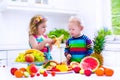 Kids eating fruit in a white kitchen Royalty Free Stock Photo