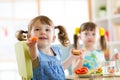 Kids eating healthy food in kindergarten or at home Royalty Free Stock Photo