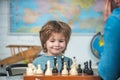 Kids educational games, early development. Young kid boy playing chess and having fun.
