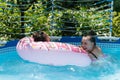 Kids enjoy swimming and floating in leisure pool during summer vacation, fun Royalty Free Stock Photo