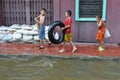 Kids are enjoying the flood with their truck tire in a flooded street of Bangkok, Thailand, on 30 November 2011