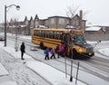 Kids entering in the school bus after a snowy night