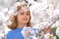 Kids face with flower on the Spring. Child in blooming cherry garden on beautiful spring day. Happy child during spring Royalty Free Stock Photo