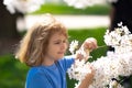 Kids face with flower on the Spring. Child in blooming cherry garden on beautiful spring day. Happy child during spring Royalty Free Stock Photo