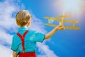 Kids fantasy. Child playing with toy airplane against sky and cl Royalty Free Stock Photo