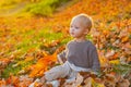 Kids fashion. Childhood memories. Child autumn leaves background. Warm moments of autumn. Toddler boy blue eyes enjoy Royalty Free Stock Photo