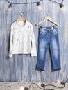 Kids fashion - Long sleeve shirt and Blue jeans set for girls; photo on wooden background