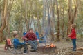 Kids with father burning a fire at camping ground Royalty Free Stock Photo