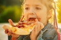 Kids favorite food. Tasty pizza. Child eating pizza. Fastfood. Italian junkfood. Little girl lunch outdoor. Royalty Free Stock Photo