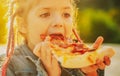 Kids favorite food. Tasty pizza. Child eating pizza. Fastfood. Italian junkfood. Little girl lunch outdoor.