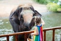 Kids feed elephant in zoo. Family at animal park Royalty Free Stock Photo