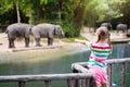 Kids feed elephant in zoo. Family at animal park Royalty Free Stock Photo