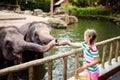 Kids feed elephant in zoo. Family at animal park Royalty Free Stock Photo