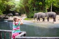 Kids feed elephant in zoo. Family at animal park Royalty Free Stock Photo