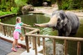 Kids feed elephant in zoo. Family at animal park Royalty Free Stock Photo