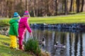 Kids feeding ducks in autumn park Royalty Free Stock Photo