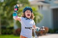 Kids first bike. Child learning to ride bike. Kid riding bike in a helmet. Child with a childs bike and in protective Royalty Free Stock Photo