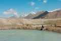 Kids fishing in a blue mountain river at the sunny morning with snow rocks