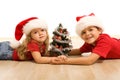 Kids on the floor with a decorated tree