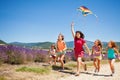 Kids flying kite running through lavender field Royalty Free Stock Photo