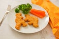 Kids food. nuggets with vegetables. Dinosaur shaped chicken, fish or turkey nuggets, ready to eat Royalty Free Stock Photo