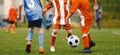 Kids Football Players Kicking Ball on Soccer Field. Youth Junior Athletes in Red and Blue Soccer Shirts Royalty Free Stock Photo