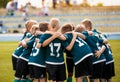Kids football team building team spirit. Soccer children team in huddle