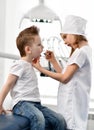 Kids girl and boy play dentist and patient in dental office. Stomatologist checks patient teeth with a dental mirror. Royalty Free Stock Photo