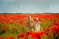 Kids girl and boy are running in front of wind generators turbines. Renewable energies and sustainable resources. Happy Royalty Free Stock Photo