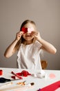 Kids, girl crafting red valetine heart card on table at home