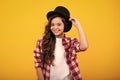 Kids girl in old fashion clothes. Elegent hat, cylinder hat isolated on yellow background. Headwear. Clothes accessories