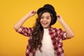 Kids girl in old fashion clothes. Elegent hat, cylinder hat isolated on yellow background. Headwear. Clothes accessories