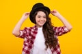 Kids girl in old fashion clothes. Elegent hat, cylinder hat on yellow background. Headwear. Clothes accessories