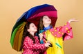 Kids girls happy friends under umbrella. Rainy weather with proper garments. Bright umbrella. It is easier to be happy