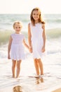 Kids, girls walking on beach with big waves in windy weather. vacation to sea Royalty Free Stock Photo