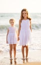 Kids, girls walking on beach with big waves in windy weather. vacation to sea Royalty Free Stock Photo