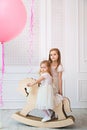 Kids girls in white dress on rocking horse