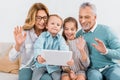 kids and grandparents waving by hands while having video call with digital tablet