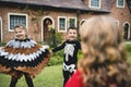 Kids in Halloween costumes holding hands in a park Royalty Free Stock Photo