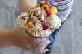 kids hand clutching a gourmet ice cream with fruit toppings