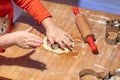 Kids hand cutting a cookie in a shapes of a star in a thin homemade pastry sheet