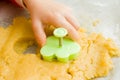 Kids hand with form of christmas cookies for children, making gingerbread in form of man. New year treat for Santa Claus cooking. Royalty Free Stock Photo