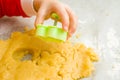 Kids hand with form of christmas cookies for children, making gingerbread in form of man. New year treat for Santa Claus cooking. Royalty Free Stock Photo