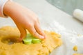 Kids hand with form of christmas cookies for children, making gingerbread in form of man. New year treat for Santa Claus cooking. Royalty Free Stock Photo