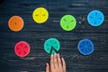 Kids hand moves colorful math fractions on dark wooden background or table. Interesting creative funny math for kids